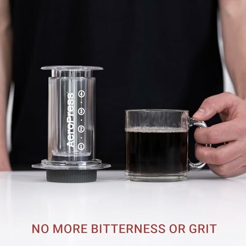 Personne avec AeroPress et tasse de café