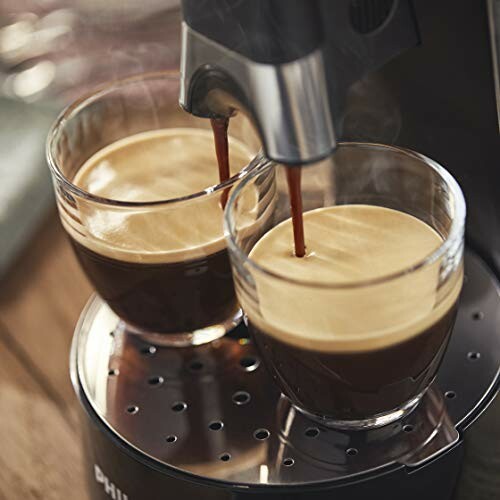 Deux tasses de café expresso sous une machine.