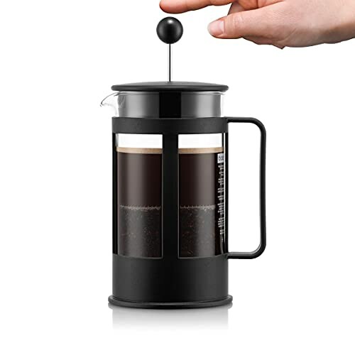 Main appuyant sur une presse française pour café
