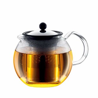 Théière en verre avec infuseur et thé.