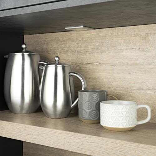Cafetière et tasses sur une étagère de cuisine.