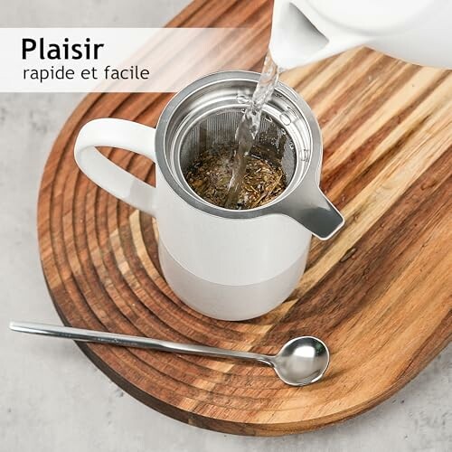 Versement de l'eau dans une théière blanche avec une cuillère.